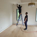 Encore Duct Cleaning technician using drop cloths to protect clean home flooring.